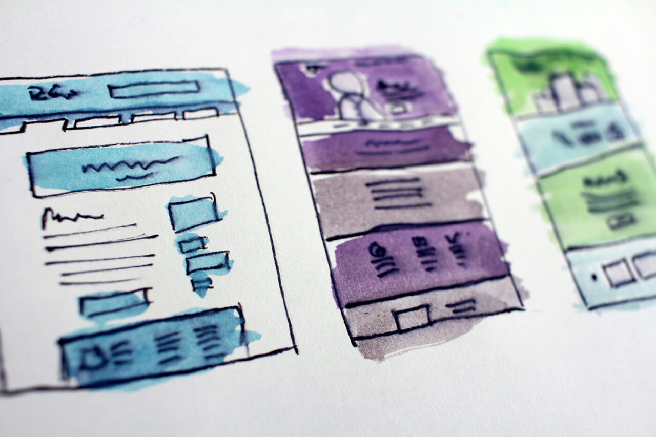 Hand-drawn watercolor website wireframes showing multiple page layouts and interface elements, illustrating early-stage UX and web design planning.