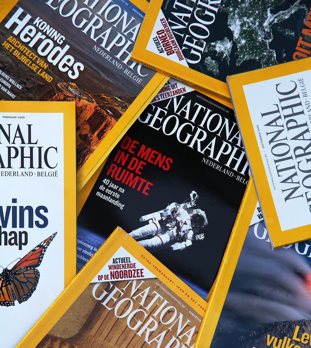 Collection of National Geographic magazine covers spanning multiple years, illustrating how the publication's design evolved while consistently retaining its iconic yellow border.